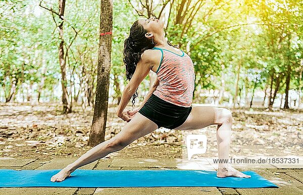 Junge Frau macht Yoga Anjaneyasana oder Mondsichel Pose. Mädchen übt Anjaneyasana mit Händen und Kopf zurück  High lunge yoga variation  Anjaneyasana