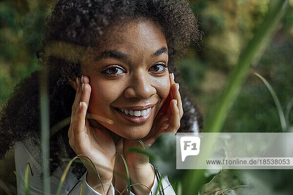 Close up Porträt der hübschen jungen afroamerikanischen Frau auf Gras liegend. Schöne afro Mädchen in einem weißen Hemd entspannt im Park. Natürlichkeit und Hautpflege Konzept. Freie Kopie spase