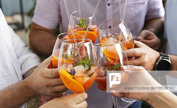 Glückliche Freunde verbringen Zeit miteinander  Fokus auf junge Frauen  die Aperol Spritz Cocktail trinken. Sommer Hochzeitsfeier. Fröhlichkeit und Feier Konzept