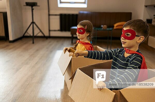 Superhelden Kinder. Superheldenkinder  Bruder und Schwester  spielen zu Hause. Bewegendes  erfolgreiches und fröhliches Spielkonzept