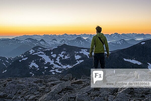 Wanderer am Gipfel des Skåla  Ausblick auf Bergpanorama  bei Sonnenuntergang  Loen  Norwegen  Europa