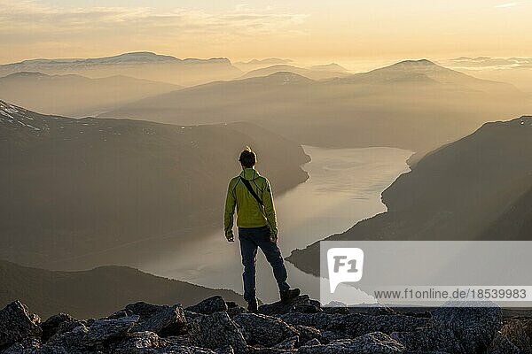 Hikers on top of Skåla  view of mountains and fjord Faleidfjorden  at sunset  Loen  Norway  Europe