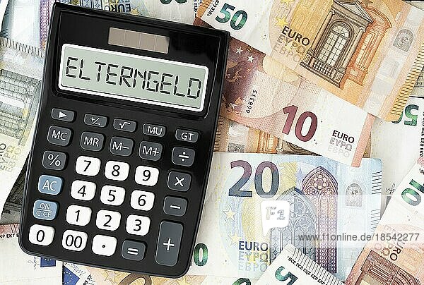 Das Wort ELTERNGELD auf dem Display des Taschenrechners gegenüber den Euro-Banknoten