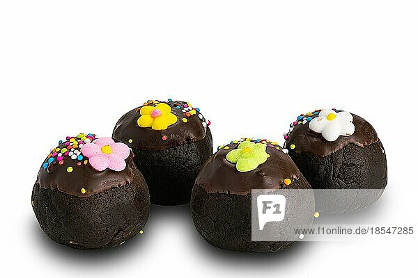 Seitenansicht der hausgemachten Schokolade Kugeln Topping mit bunten Regenbogen Streuseln und Zucker Blume auf weißem Hintergrund mit Clipping-Pfad