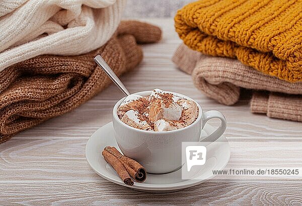 Cozy Winter Zusammensetzung  Tasse mit heißer Schokolade oder Kakao mit Marshmallow und Stapel von warmen gestrickte Kleidung auf weißem Holz rustikalen Hintergrund. Gemütliche und weiche Winter zu Hause  freier Raum für Text