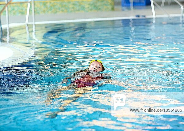 Child swimming backstroke in the pool