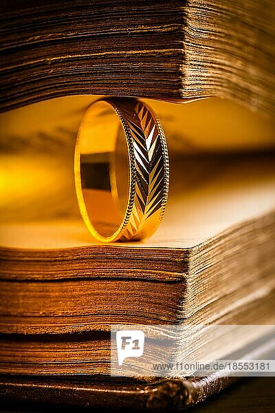 Goldener Ring zwischen den Seiten eines alten Buches im Vintagestil Nahaufnahme  Weichzeichner