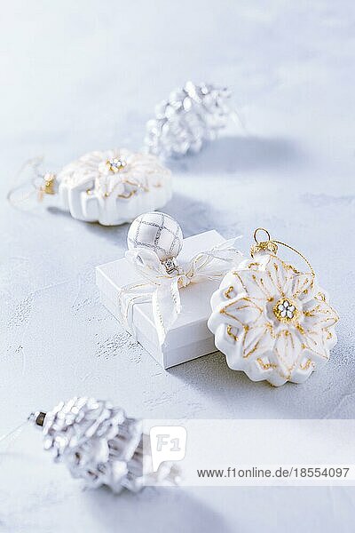Arrangement aus Weihnachtsschmuck  Kerzen und kleinen Geschenken in schneeweiß