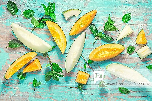 Gesunder Snack Piel de sapo Melone und Cantaloupe mit frischer Minze auf dem Zyan Holztisch