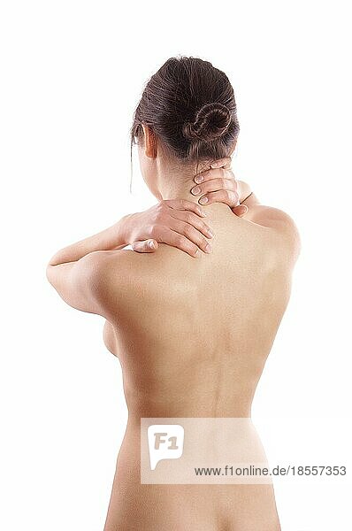 Nackte junge Frau mit Rücken- oder Nackenschmerzen von hinten gesehen