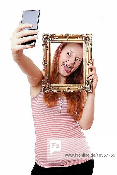 Junge Frau  die ein albernes Selfie mit Bilderrahmen mit Fotohandy macht