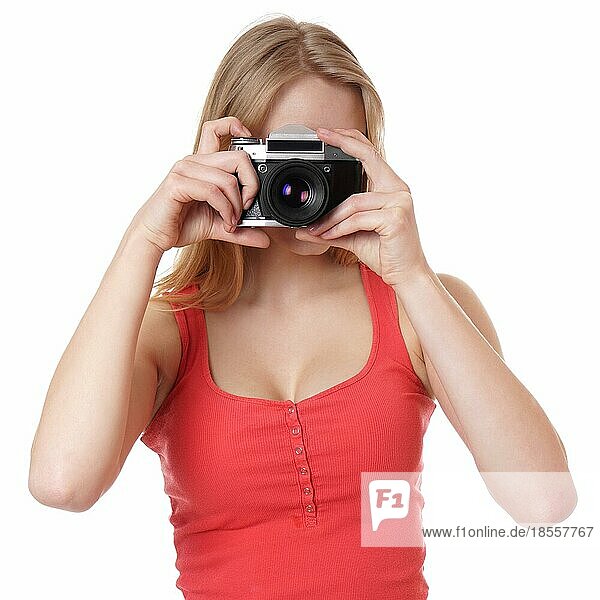Junge Frau beim Fotografieren mit analoger Kleinbildkamera
