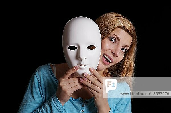 Junge Frau  die eine weiße Maske von ihrem Gesicht entfernt