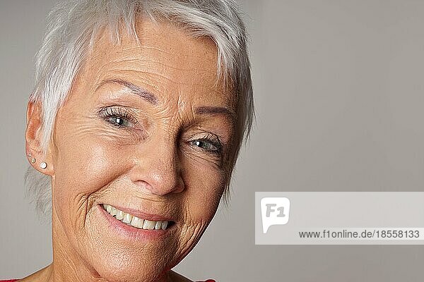 Nahaufnahme einer älteren Frau in den Sechzigern mit strahlendem Lächeln