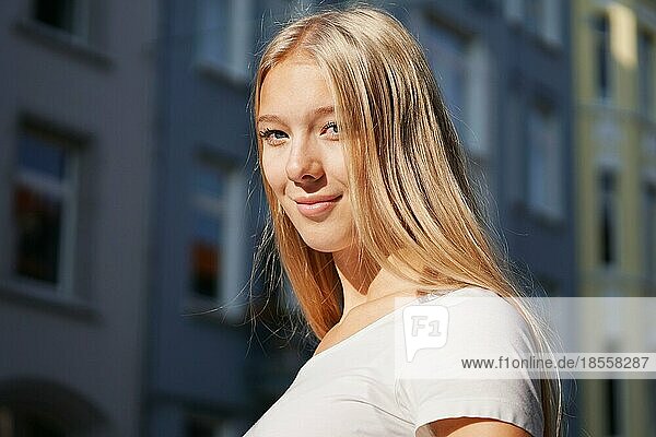 candid urban portrait of blond young woman on city street