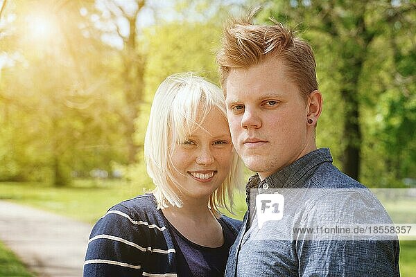 Junges Paar genießt sonnigen Frühlingstag in einem Park - echte Menschen mit Sonne Flare Licht Leck Filter