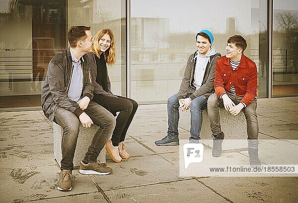 group of young teenage friends talking and laughing together - candid real people with vintage filter
