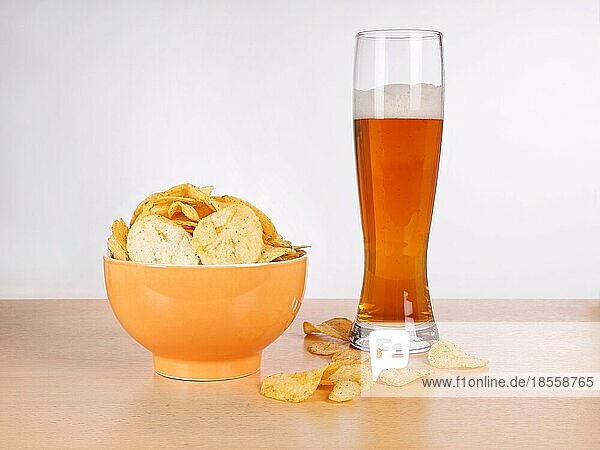 Eine Schale Kartoffelchips oder Chips und ein Glas Weizenbier