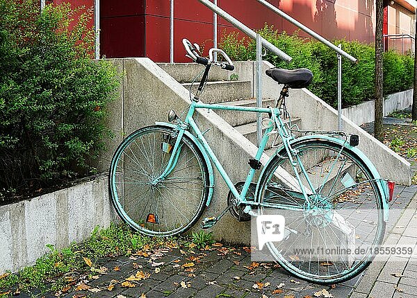 Bemaltes Fahrrad  das an einem Geländer vor einem Studentenwohnheim in Deutschland befestigt ist