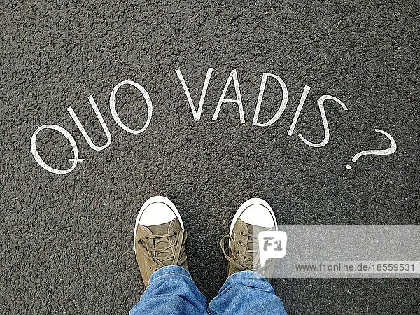 Quo vadis ist eine lateinische Redewendung und bedeutet Wohin gehst du? - Fuß-Selfie auf der Straße mit einer auf den Asphalt geschriebenen Frage - Verwirrung  Schicksal  Unsicherheit - Konzept