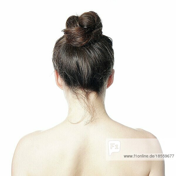 Kopf und Schulter Rückenansicht einer jungen Frau mit unordentlichem Dutt - undone hair style fashion trend