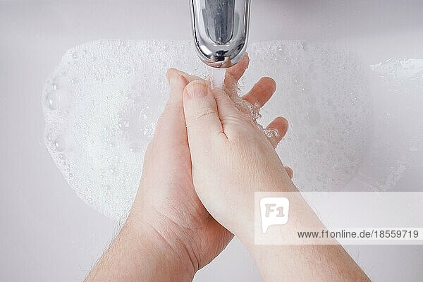 Händewaschen mit Wasser und Seife aus der persönlichen Perspektive - Hygienekonzept mit unkenntlicher männlicher Person und geringer Tiefenschärfe