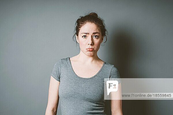 Mürrische  schmollende junge Frau in den 20ern  die sich enttäuscht fühlt - negative Emotion  schlechte Laune  Konzept mit Copy Space