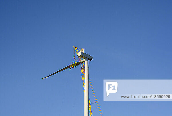 Wind turbine under construction against clear sky
