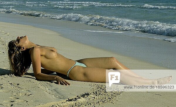 Nackte Frau am Strand beim Sonnenbaden