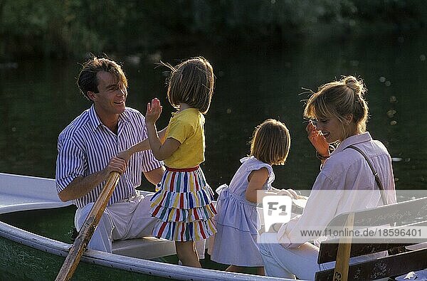 Junge Familie mit 2 zwei Kindern in einem Ruderboot  Mädchen  Eltern  Mutter  Vater