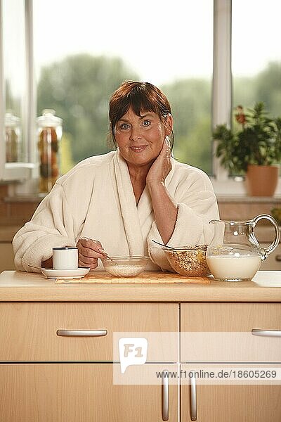 Frau beim Frühstück  Frühstück  frühstücken  Kanne Milch  Schüsseln  Müsli  Tasse Kaffee  frühstückt