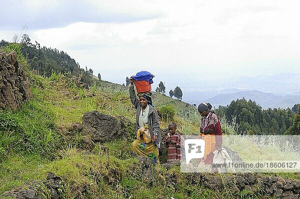 Woman and children on mountainside  Volcano National Park  Rwanda  Africa