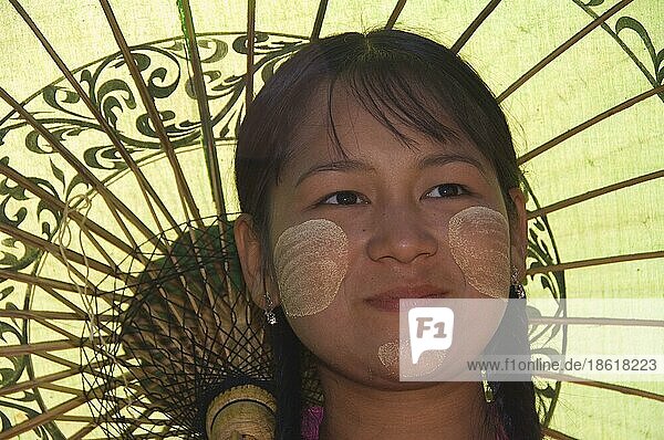 Junge Burmesin mit Sonnenschirm und Thanaka-Paste im Gesicht  Bagan  Burma  Pagan  Myanmar  Gesichtsbemalung  Asien
