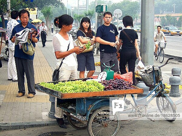 Straßenverkäuferin mit Weintrauben auf Fahrrad  Peking  Obst-Verkäuferin  Obstverkauf  China  Asien