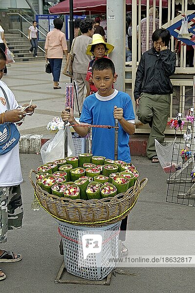 Boy selling roses wrapped in banana leaves  Chatuchak Market  Bangkok  Thailand  Junge verkauft Rosen eingewickelt in Bananenblätter  Chatuchak-Markt  Bangkok  Thailand  Asien