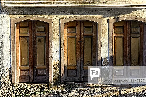 Alte  vom Zahn der Zeit gezeichnete Holztüren an der Fassade eines Hauses im Kolonialstil in der Stadt Ouro Preto  Minas Gerais  Brasilien  Südamerika
