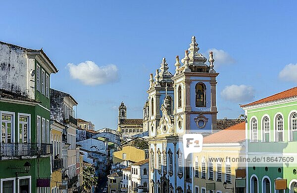 Farbenfrohe Fassaden alter Kolonialhäuser und historische Kirchtürme im Barock und Kolonialstil mit blauem Himmel im berühmten Pelourinhoviertel von Salvador  Bahia  Brasilien  Südamerika