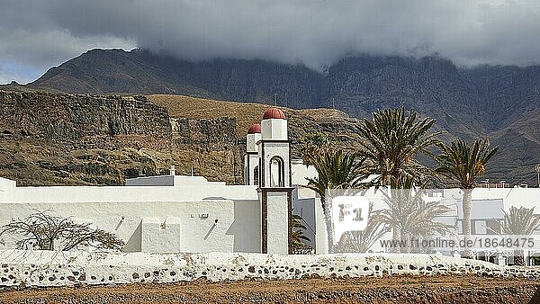 Ermita de las Nieves  Einsiedelei  Kirche  Seitenansicht  Berge  dichte grauweiße Wolkendecke  Palmen  weiße Steinmauern  Puerto de las Nieves  Westküste  Gran Canaria  Kanarische Inseln  Spanien  Europa