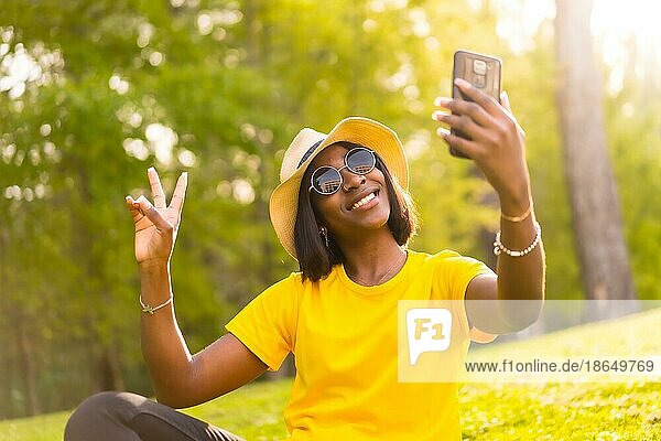 Lächeln für die Kamera: Ein afroamerikanischer Tourist macht ein Selfie im Wald