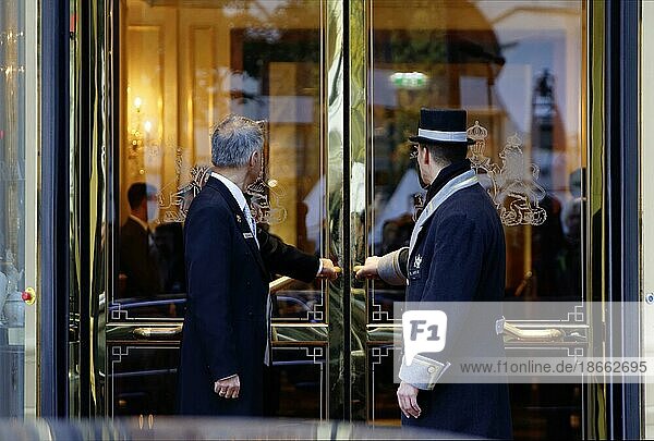 A uniformed car attendant and a concierge of the Hotel Imperial open the hotel door  city view  Vienna  Austria  Europe