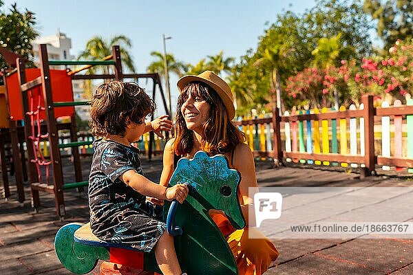 Mother playing with her son in a playground on summer vacation