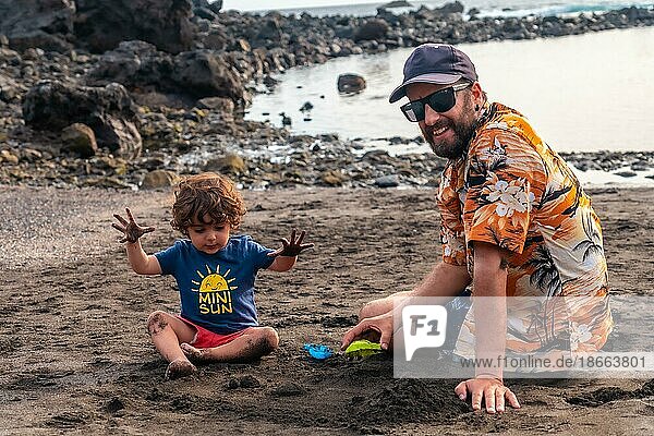 Porträt eines Vaters mit seinem Sohn beim Spielen am schwarzen Sandstrand von Valle Gran Rey auf La Gomera  Kanarische Inseln