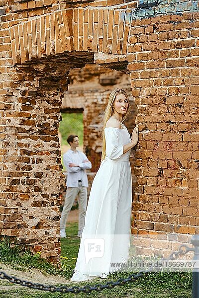 Young couple in love posing among ruins of a castle