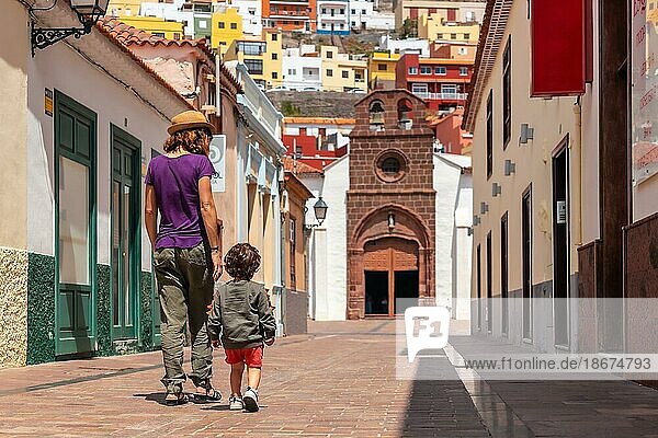 Vacation concept  mother with her son walking in the city of San Sebastian de la Gomera next to the Iglesia De La Asuncion  Canary Islands
