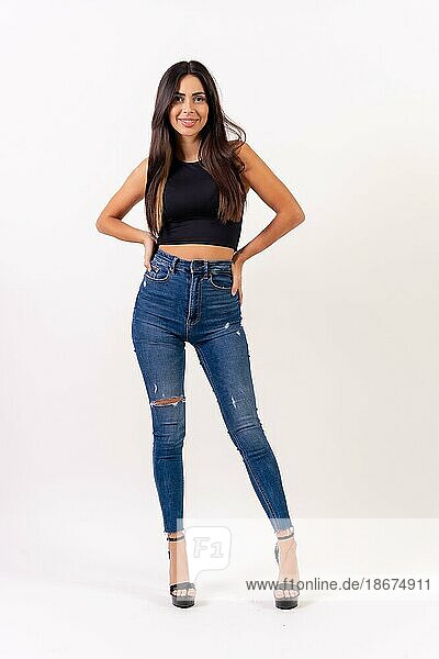 Brunette woman in casting photos on a white background  in jeans and a black t-shirt