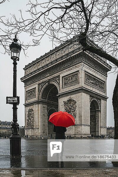 Women with red umbrella in front of the Arc de Triomphe  Paris  France  Europe