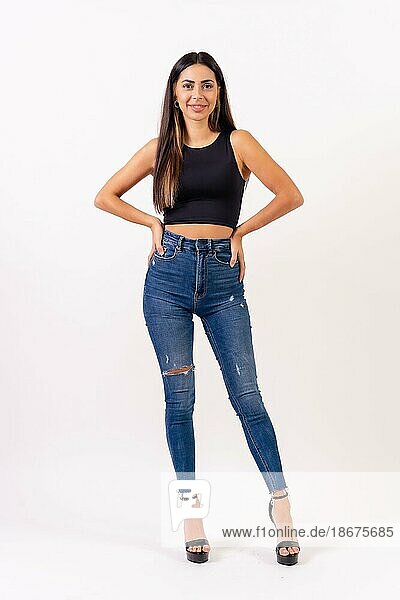 Brunette woman in casting photos on a white background  in jeans and a black t-shirt smiling