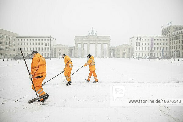 Berlin  Three employees of the BSR (Berliner Stadtreinigung) sweep snow  taken on Pariser Platz in front of the Brandenburg Gate after during heavy snowfall in Berlin