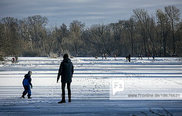 People walk across the ice and skate on the frozen Hermsdorfer See lake in Berlin Reinickendorf. Berlin  13.02.2021  Berlin  Germany  Europe