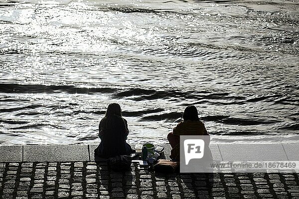 Zwei Frauen entspannen in der Mittagssonne am Spreebogen im Regierungsviertel in Berlin  24.02.2021. Copyright: Berlin  Deutschland  Europa